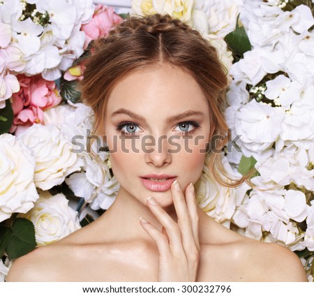 Portrait of a beautiful fashion bride, sweet and sensual. Wedding make up and hair. Flowers background. Art modern style. Blue eyes. Natural manicure.