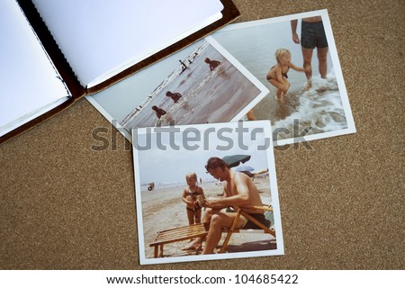 Old photo album and photographs from the early 1970's of family at a beach on a bulletin board.