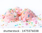 Small photo of pink berry scoops ice cream strewed sprinkles, marshmallows and icing on white background