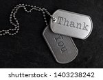 Small photo of Old and worn military dog tags - Thank You