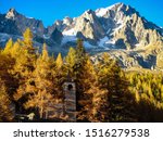             The church of the Planpinicieux village in the Italian Val Ferret, with the Grandes Jorasses peak on the top right and the Planpincieux Glacier on the top left                   