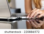 Close up of a woman hand plugging a pendrive on a laptop at home