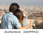Back view of a couple dating in love hugging and looking the city in a sunny day