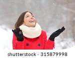 Candid happy girl enjoying snow in winter wearing a red jacket