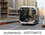 Small photo of TOKYO, JAPAN - March 17, 2021: A hydrogen fuel cell bus passing part of new Tokyo Olympic Village in Harumi. Some motion blur.