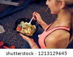 Top view of woman eating healthy food while sitting in a gym. Heatlhy lifestyle concept.