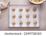 Small photo of Chocolate chip cookie dough scooped on a cookie sheet ready to be baked