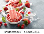 Strawberry and raspberry ice cream popsicles in white bowls
