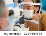 Small photo of Optometrist using slit lamp to view structures of patients eye such as cornea, iris, and lens during exam