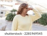 Small photo of middle age woman feeling disgusted, holding nose to avoid smelling a foul and unpleasant stench