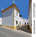 Small photo of Vernacular architecture of traditional townhouses newly whitewashed and painted yellow and giving onto a cobbled blind alley -beco- lateral to a main street in the old town. Tavira-Algarve-Portugal.