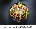 mexican street tacos flat lay composition with pork carnitas, avocado, onion, cilantro, and red cabbage