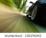 Front side view of black car driving fast.