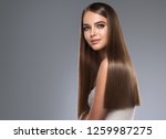 Beautiful model girl with shiny brown and straight long hair. Keratin  straightening. Treatment, care and spa procedures. Smooth hairstyle