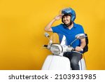 Delivery man wearing blue uniform riding motorcycle and delivery box isolated on yellow background. Motorbike delivering food or parcel express service