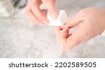 Small photo of Woman finishing her manicure at home with simple manicure tools. Buffering nails with a nail buffer block.