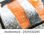 Small photo of The store-packaged fresh salmon pieces are neatly arranged and securely sealed in a styrofoam package, ready for purchase and subsequent preparation in a variety of delicious dishes.