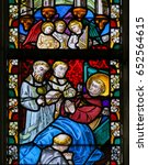 Small photo of GHENT, BELGIUM - DECEMBER 23, 2016: Stained Glass window depicting praying monks next to the deathbed of a Christian Saint in the Cathedral of Saint Bavo in Ghent, Belgium.