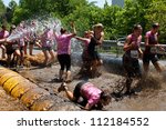 Small photo of ATLANTA, GA , USA - APRIL 28, 2012: Women competing in the Dirty Girl Mud Run, run through a mud pit and get soaked with a hose as they near the finish of the women only race on April 28, 2012 in Atlanta.
