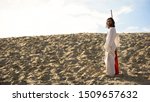 Small photo of Hermit with staff walking in desert looking to camera, asceticism and fasting