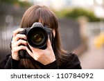 Woman taking a photo in the city during the day with bokeh background