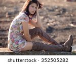 Woman in Floral Dress and Thigh High Boots Outdoors