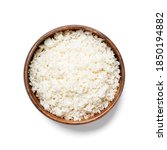 Small photo of Freshly grated raw cauliflower rice in wooden bowl isolated on white background