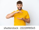 Young handsome caucasian man isolated on white background holding copyspace imaginary on the palm to insert an ad
