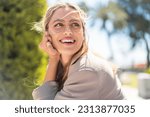 Pretty blonde Uruguayan woman with glasses at outdoors With happy expression