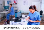 Small photo of Team of doctors working in hospital clinic, nurse man talking at phone and assistent taking notes. Medical physician in medicine uniform writing list of consulted, diagnosed patients, making research.