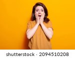 Small photo of Portrait of terrified person holding hands on face to pose on camera. Scared woman screaming and being afraid, having anxious expression in studio. Frightened adult with emotions