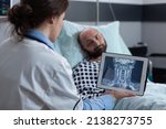 Small photo of Medical doctor presenting options to patient for treating throat affliction while looking at mri scan on digital tablet. Middle aged man with cervical issues having low oxygen saturation.