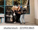 Small photo of Shocked woman catching falling pizza boxes pile, clumsy pizzeria courier dropping fastfood packages stack at customer in front of office building. Bad food delivery service