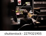 Small photo of Fbi agent working at missing case analyzing police evidence, checking crime investigation report. Private detective sitting at desk in federal bureau, planning confidential strategy to catch suspect