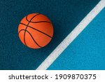 Small photo of Orange basketball on blue court of gymnasium sport floor. Team sport concept