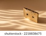 Small photo of Gold fancy retro old audio cassette tape on beige color background. Retro mixtape, 1980s pop songs tapes and stereo music cassettes