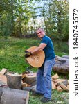 Small photo of Strong lumberjack manhandling the logs