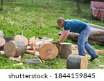 Small photo of Strong lumberjack manhandling the logs