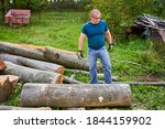 Small photo of Strong lumberjack manhandling the logs