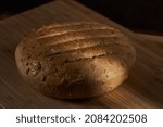 Small photo of A truckle of matured cheese homemade on a wooden board