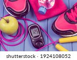 Glucose meter with result of sugar level, pair of sport shoes and accessories for fitness. Diabetes and healthy sporty lifestyles