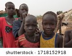 Small photo of JUBA, SOUTH SUDAN - FEBRUARY 28 2012: Unidentified kids pose for pictures at displaced persons camp in Juba, South Sudan. Juba is full of refugees who live with their children in appalling conditions.