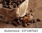 Small photo of COFFEE BEANS IN A PAPER PACKET WITH A FEW SPILT BEANS AND A PARTIALLY SHELLED PECAN NUT