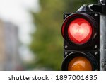 traffic control semaphore with red heart-shape in semaphore  on a defocused city background, Valentine day concept