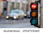 blurred view of city traffic with traffic lights, in the foreground a semaphore with a red light
