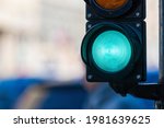 closeup of traffic semaphore with green light on defocused city street background with copy space