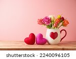 Happy Valentine's day concept with rose flowers and heart shapes on wooden table over pink background