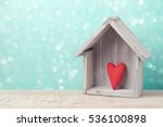 Valentine's day concept with heart shape and house over rustic background