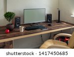 Empty office with large desktop computer monitor, speakers and bonsai on a wooden desk with mobile phone