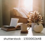 Autumn still life. Coffee cup, flowers, book and pumpkin. Hygge lifestyle, cozy autumn mood. Flat lay, Happy thanksgiving background
